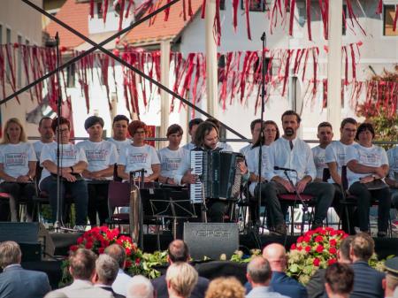Harmonikar Marko Hatlak, desno dramski igralec Iztok Bevk, zadaj MePZ dr. Frančišek Lampe